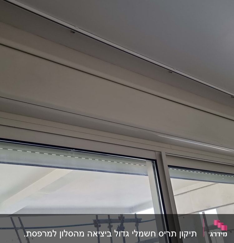 תריסים סגורים בתוך מסגרת חלון זכוכית לבנה
